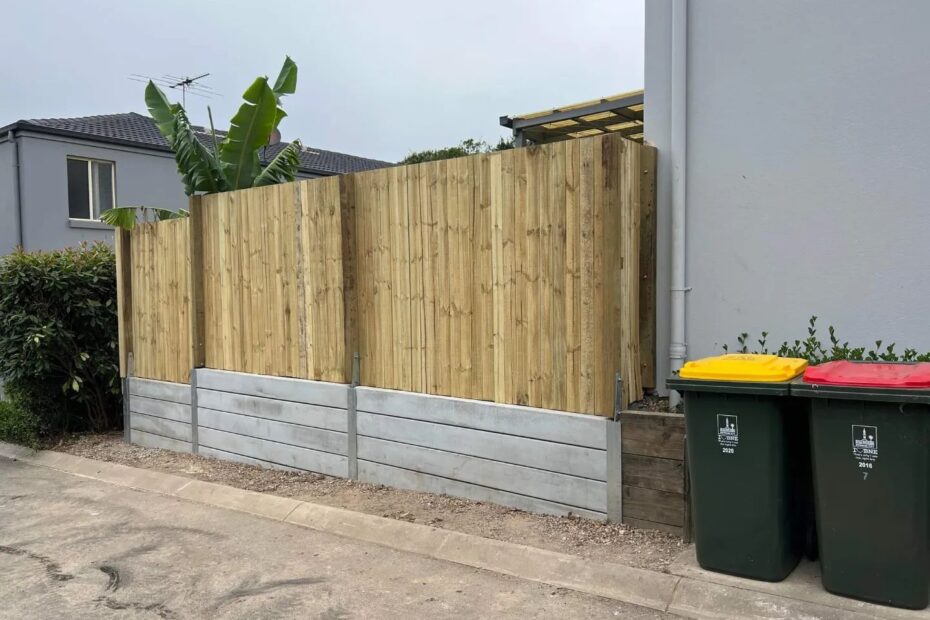 Small boundary concrete retaining wall and timber fence