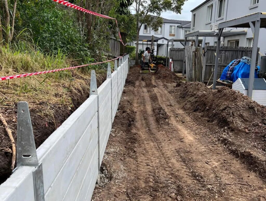 The first step in erecting a concrete retaining wall is laying a solid foundation